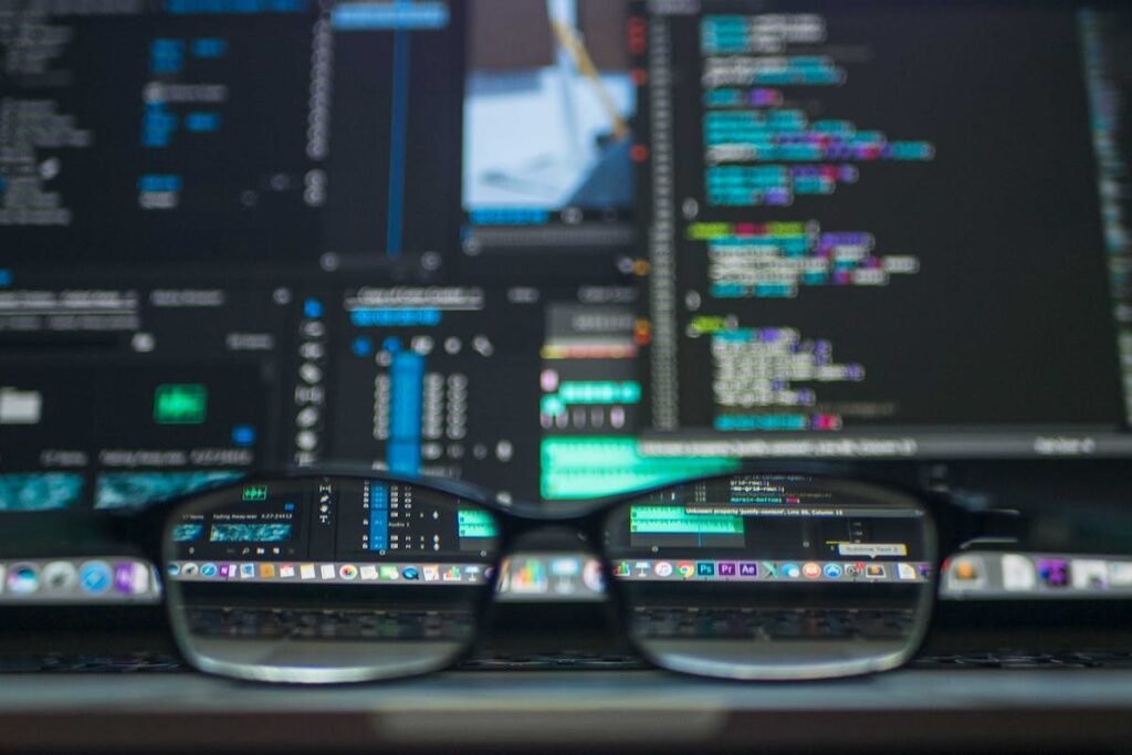 A pair of glasses sitting on top of a computer screen at Agile Development LLC.
